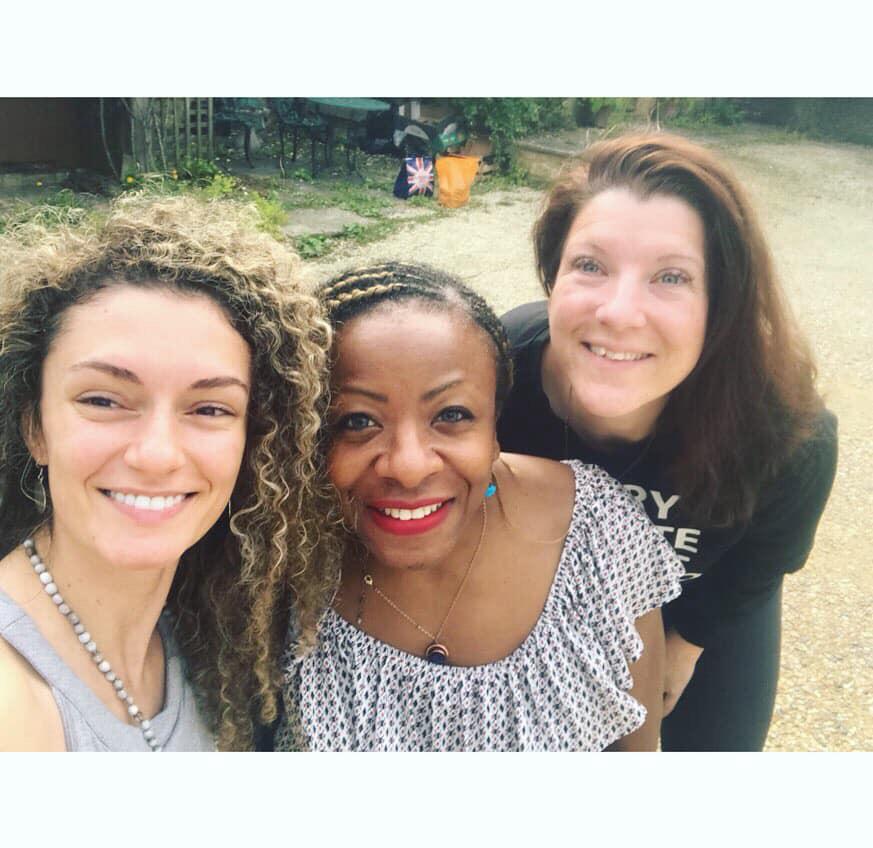 Three retreat participants smiling outdoors